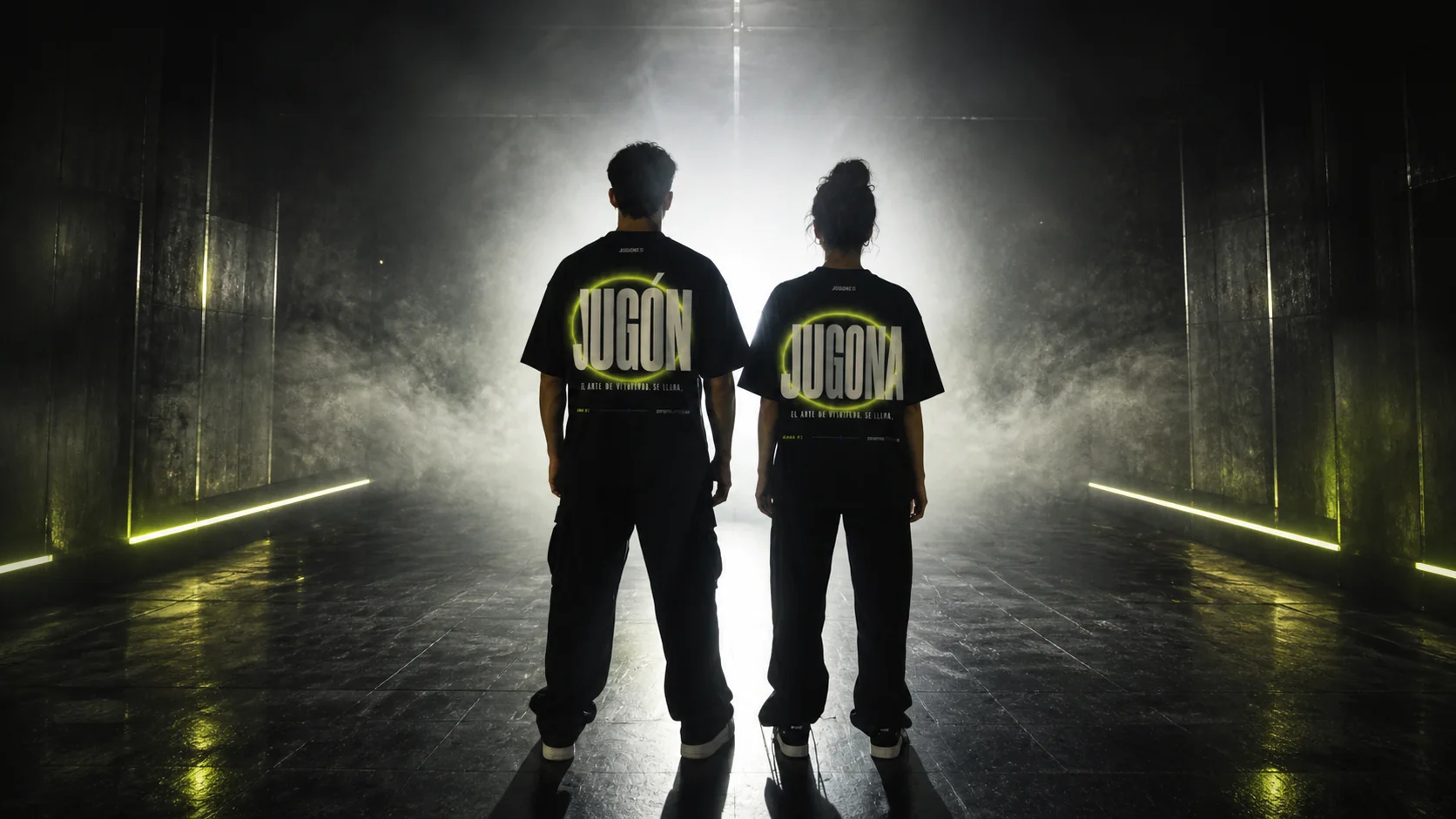 Dos personas de espaldas en un túnel con niebla, con las camisetas JUGÓN y JUGONA y el halo de aura encendido en la espalda